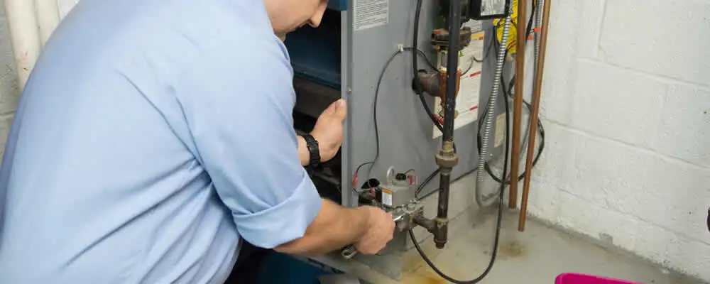 Furnace repair technician inspecting and servicing a home heating system in Redmond, WA