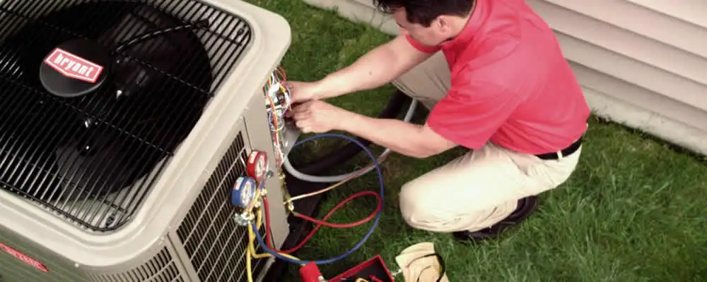 HVAC technician servicing an outdoor air conditioner unit in Redmond, WA