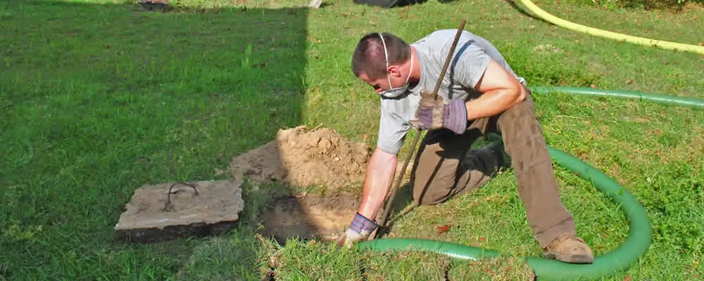 Septic pumping technician servicing a residential septic tank in Redmond, WA